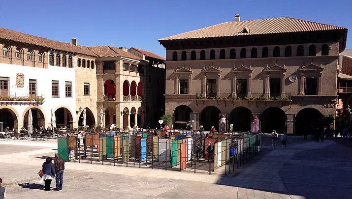 Vista aérea de El Gran Laberint en una plaza medieval, ante una pareja mayor que lo mira con asombro